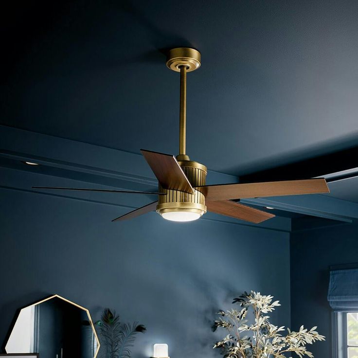 a living room with blue walls and a ceiling fan hanging from the ceiling above a bed