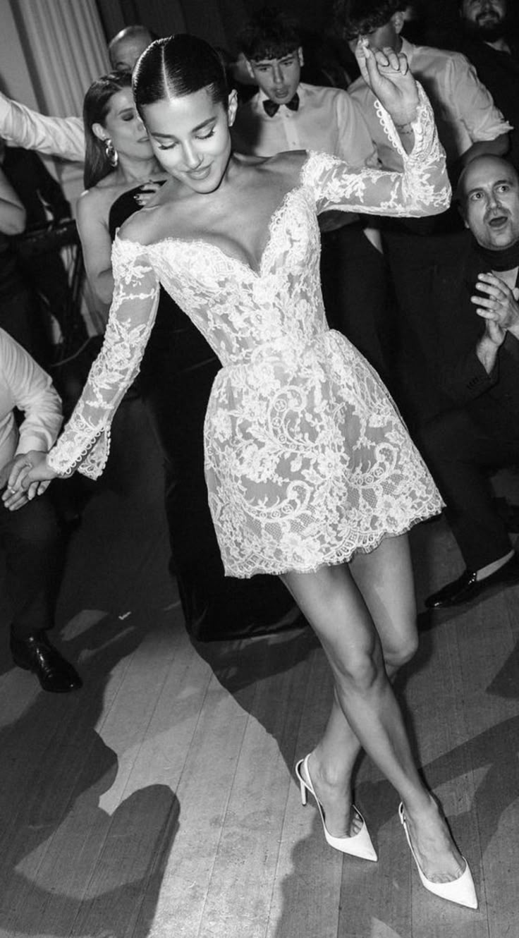 a black and white photo of a woman in a short dress on the dance floor