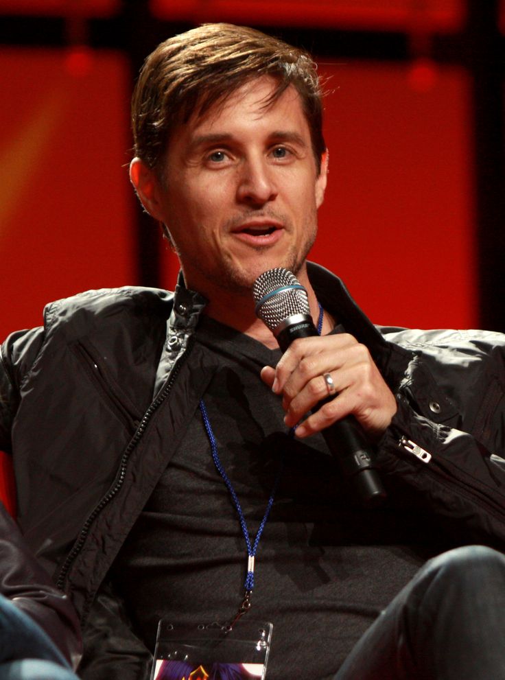 a man sitting in a chair holding a microphone