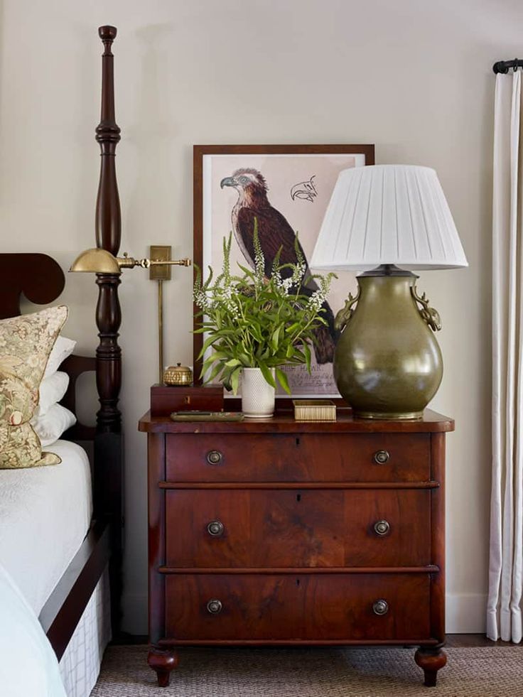 a bed room with a lamp and a dresser