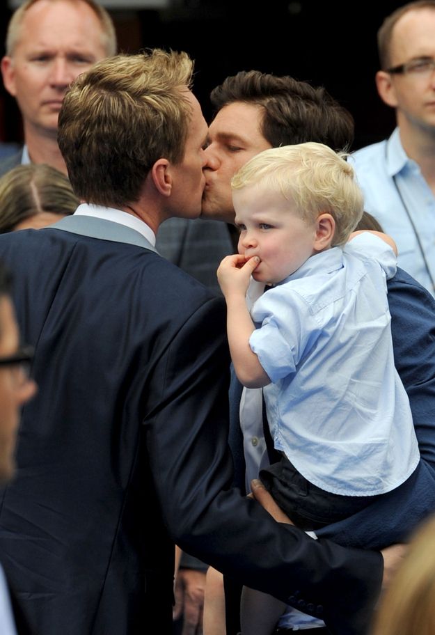 a young boy is being kissed by his father as he stands in front of an audience