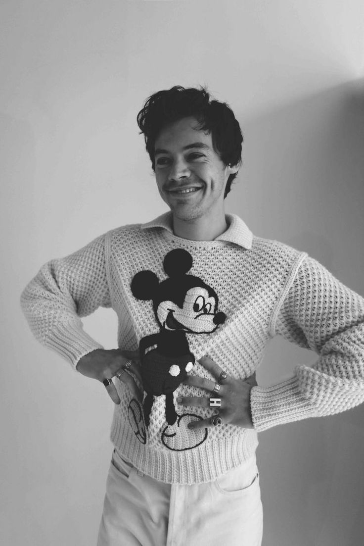 a young man wearing a mickey mouse sweater