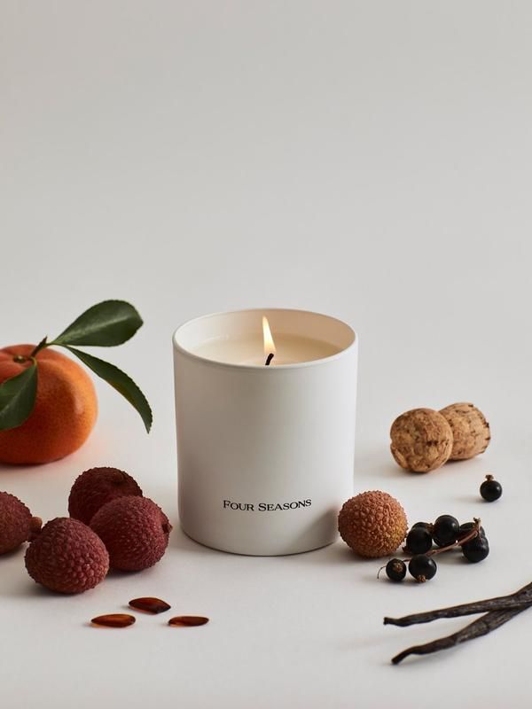 a white candle surrounded by berries and cookies