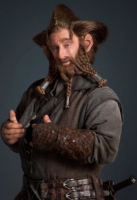 a man with long braids and a beard is dressed in an old - fashioned outfit