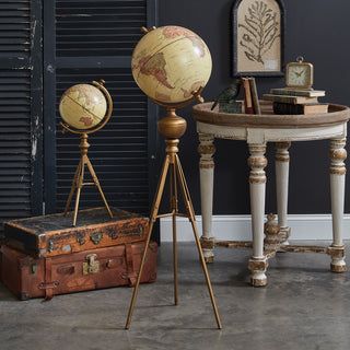 three antique world globes and an old suitcase