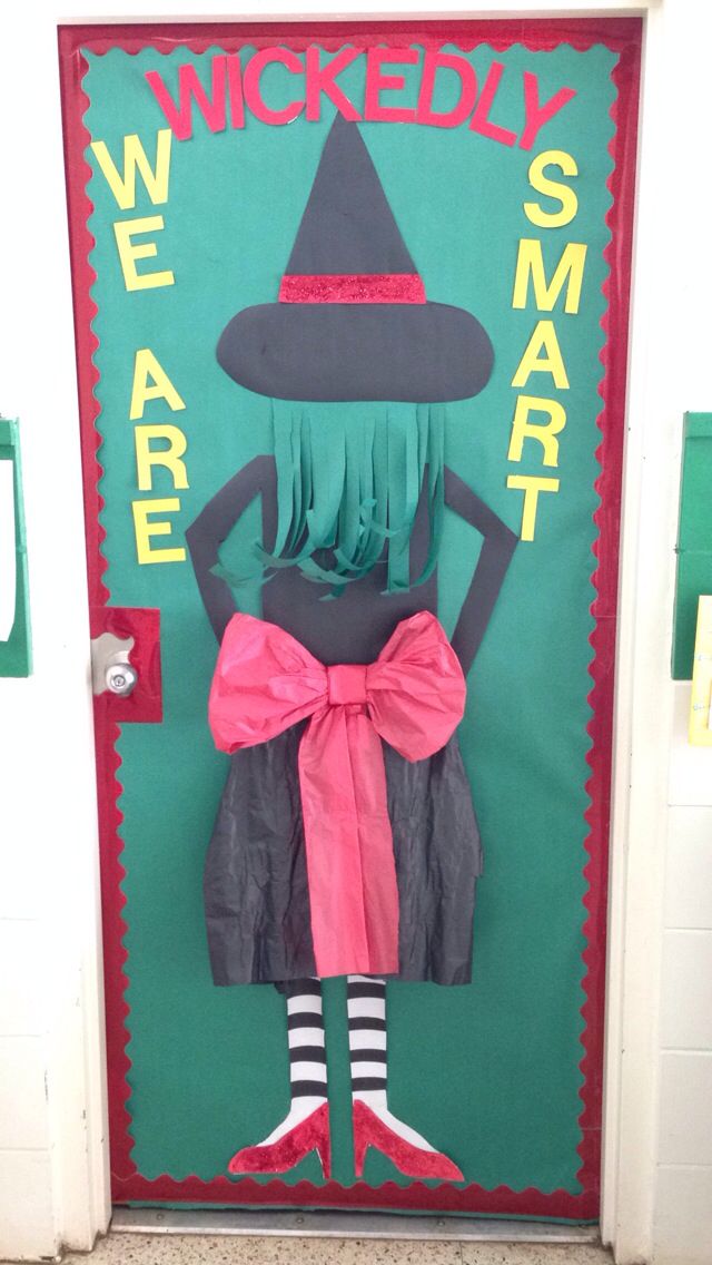 a door decorated with an image of a woman wearing a witches costume and holding a pink bow