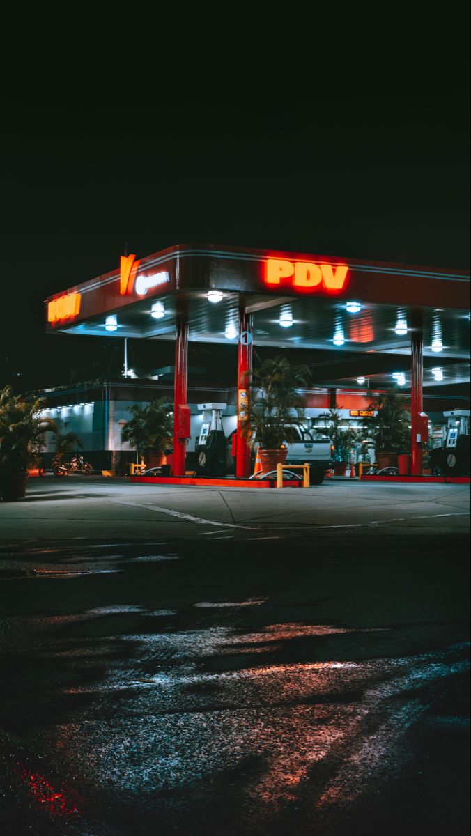 an empty gas station at night with the lights on