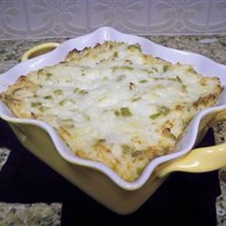 a casserole dish with cheese and vegetables in it sitting on a counter top