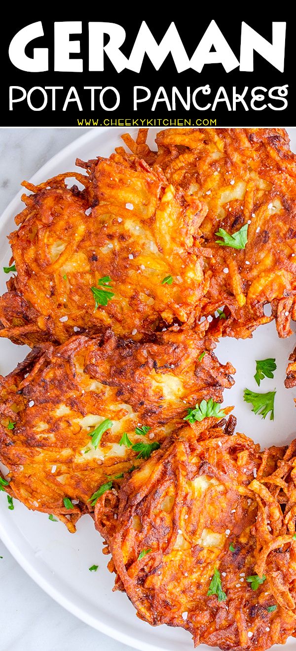 a white plate topped with potato pancakes covered in grated cheese and garnished with parsley