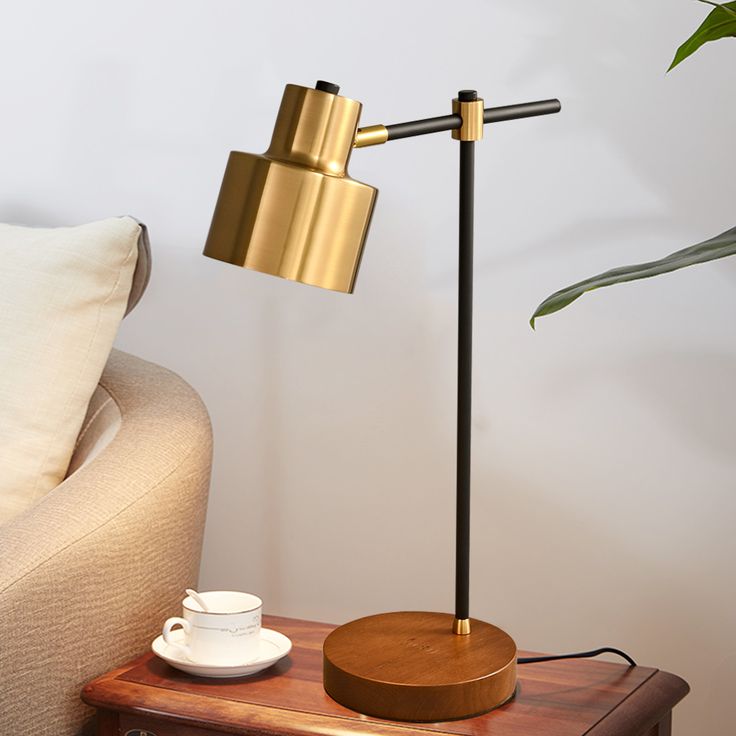 a wooden table with a lamp on it next to a couch and potted plant