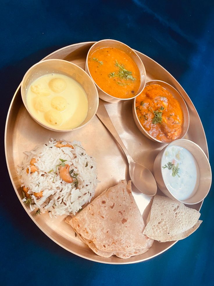 a plate with different types of food on it and sauces in bowls next to each other