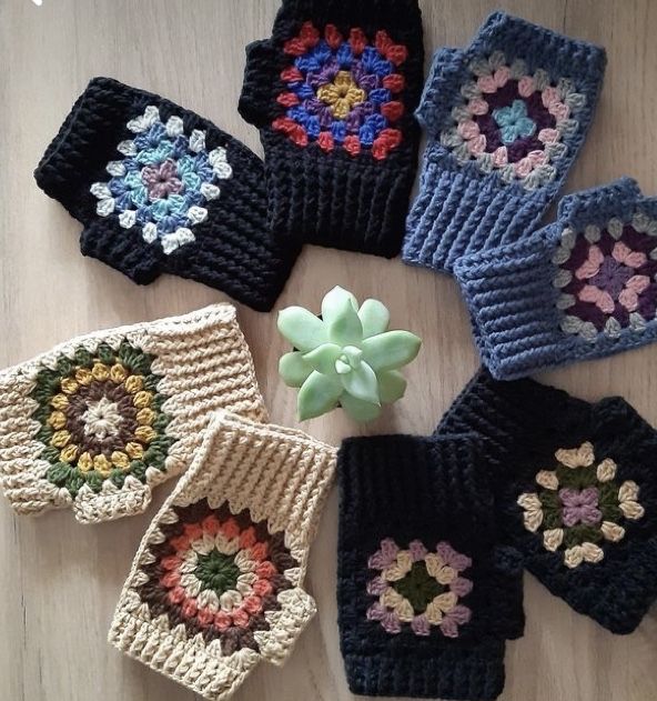 six crocheted potholders are arranged on a table with a flower in the center