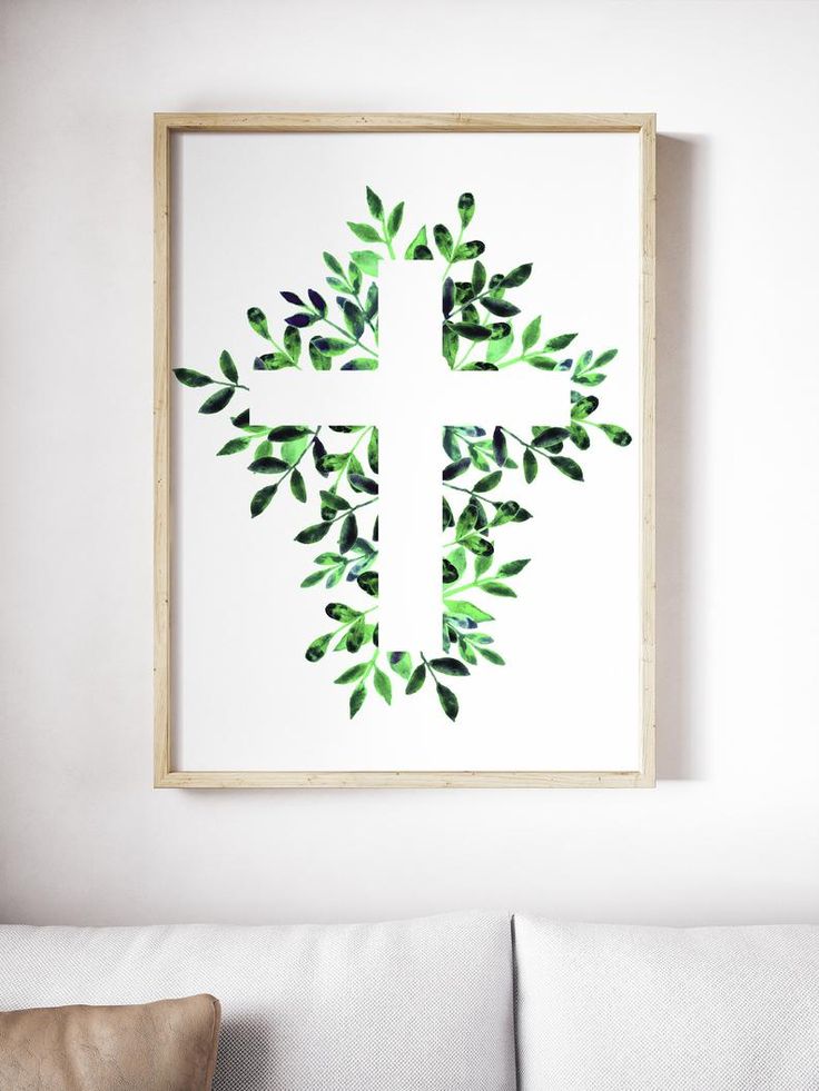 a cross made out of leaves hangs on the wall above a couch in a living room