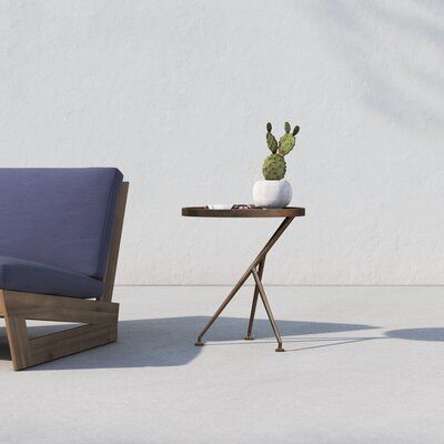 a small table with a plant on it next to a chair