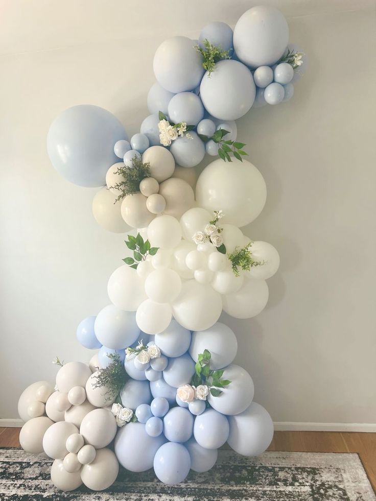 balloons and greenery are arranged in the shape of a tower