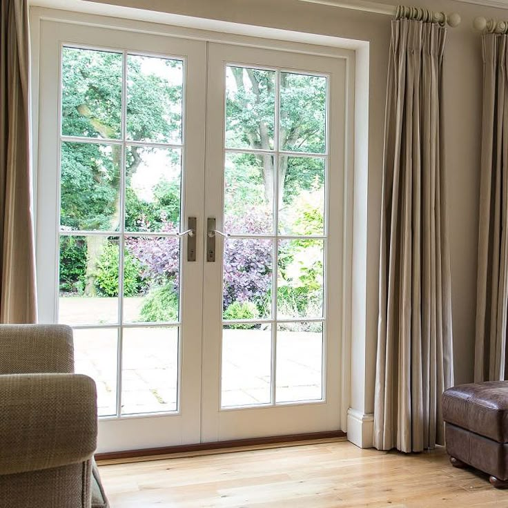 a living room with two couches and french doors leading to the outside patio area