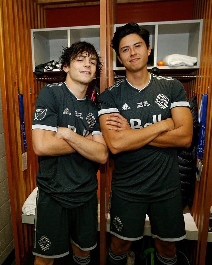 two soccer players are standing in the locker room