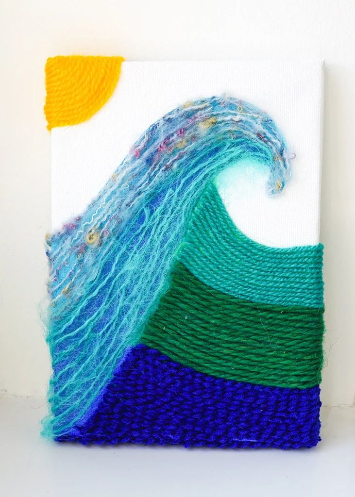 a piece of art that looks like a wave in the ocean with blue, green and yellow colors