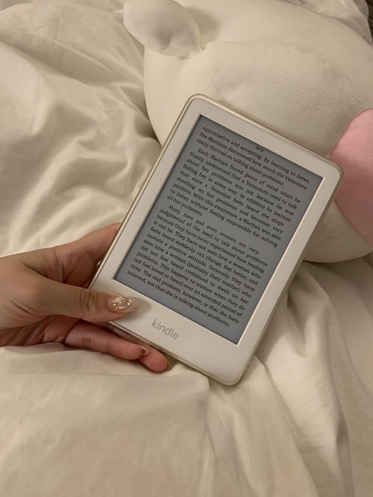 a person laying in bed with an electronic book