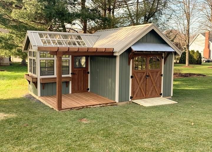 a small shed with a wooden roof in the grass