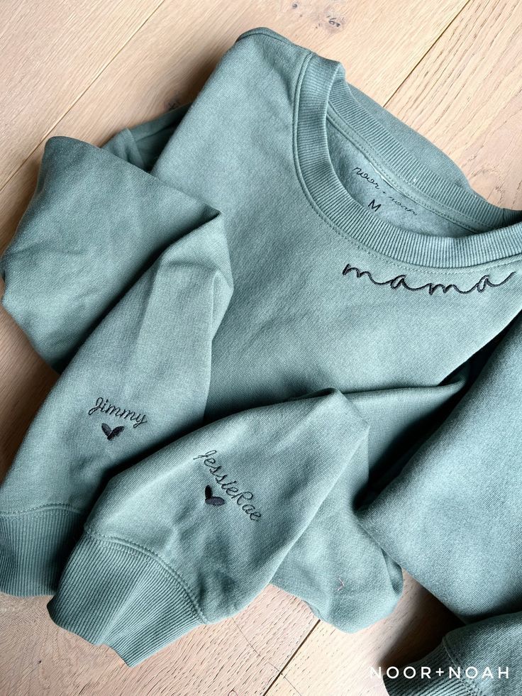 three sweaters with the word mama written on them sitting on a wooden floor next to each other