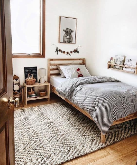 a bedroom with a bed, nightstands and rug on the floor in front of a window