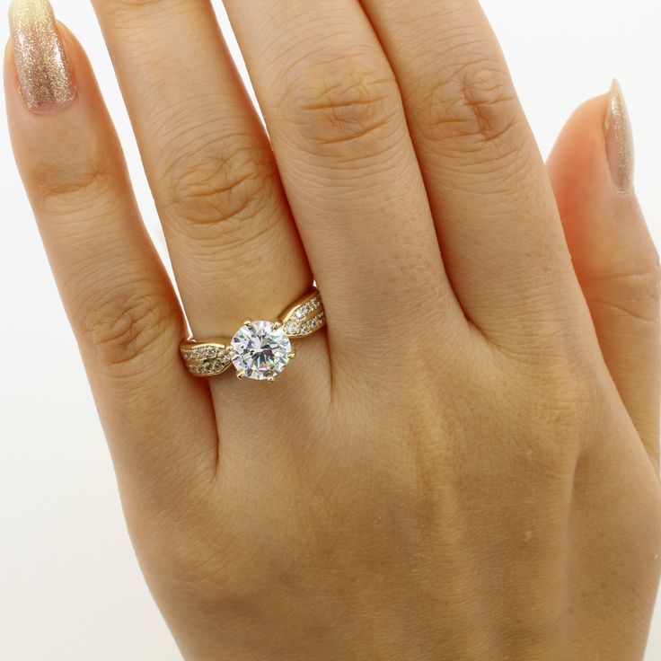 a woman's hand with a gold ring and diamond engagement ring on her finger