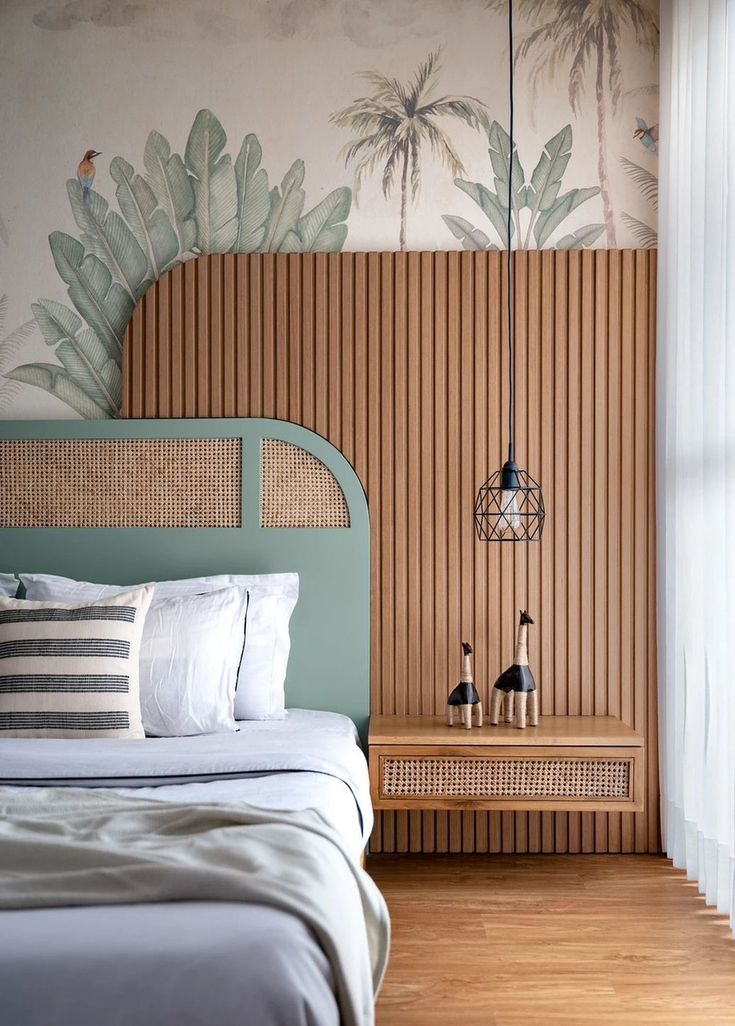 a bed sitting in a bedroom next to a wall with palm trees painted on it