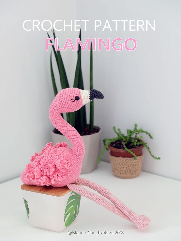 a crochet flamingo sitting on top of a potted plant