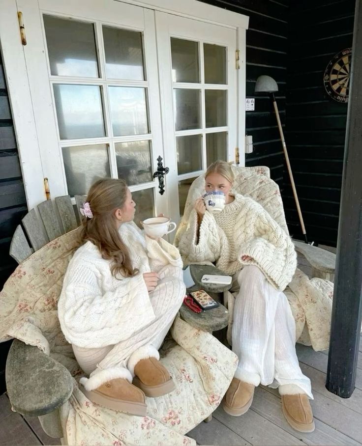 two women sitting on the porch drinking coffee