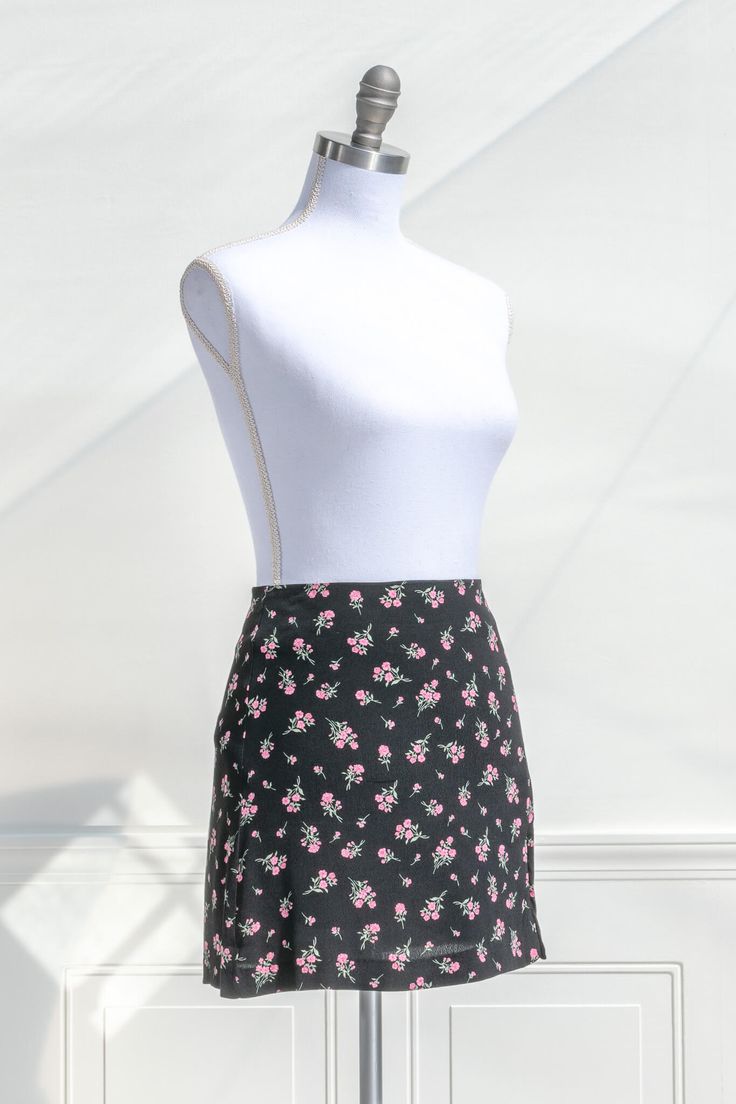 short skirts - a beautiful pink floral on black short skirt. quarter side view. amantine. Spring Mini Skort With Lined Skirt, Chic Mini Skirt With Floral Print, Chic Floral Print Mini Skort, Floral Print Mini Skirt For Spring, Feminine Floral Print Mini Skirt, Feminine Floral Mini Skirt, Fitted Feminine Floral Print Skort, Floral Print Mini Skort, Floral Print Mini Skirt