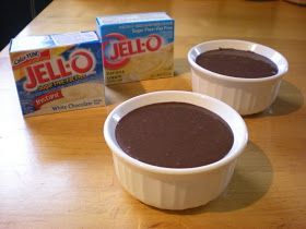 two bowls of chocolate pudding next to a carton of jello on a table