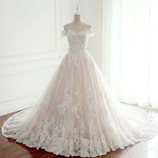 a wedding dress is displayed on a mannequin in front of a white wall