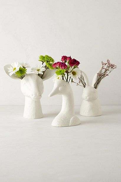 three white vases with flowers in them