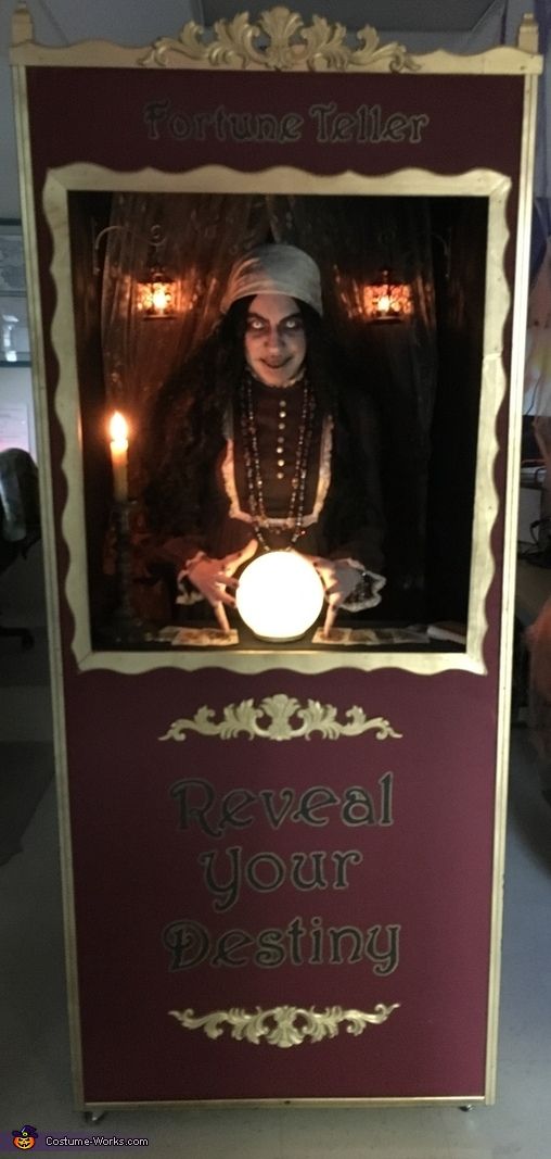 a woman is sitting in front of a sign that says reveal your identity on it