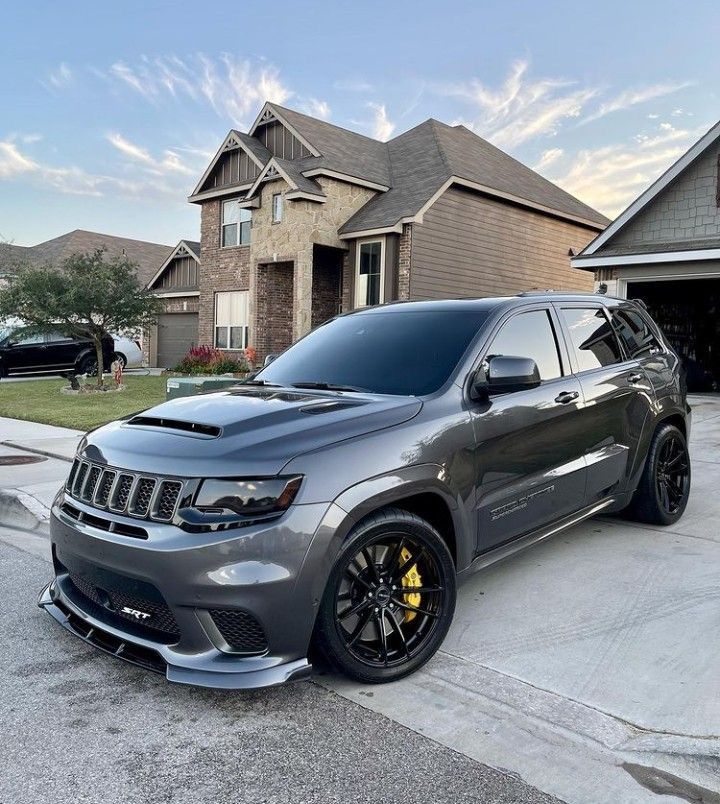 a grey jeep parked in front of a house