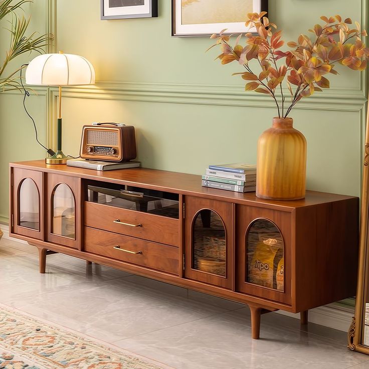 a living room scene with focus on the entertainment center and vase full of flowers in it