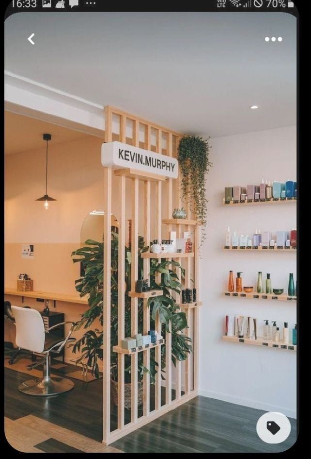 the interior of a hair salon with shelves and plants