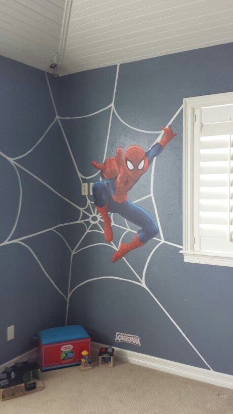 a spiderman mural in a child's room with blue walls and white shutters