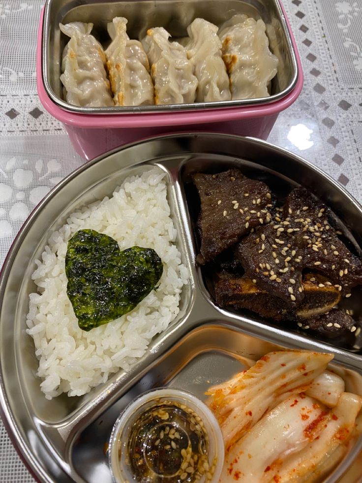 two metal trays filled with food on top of a table