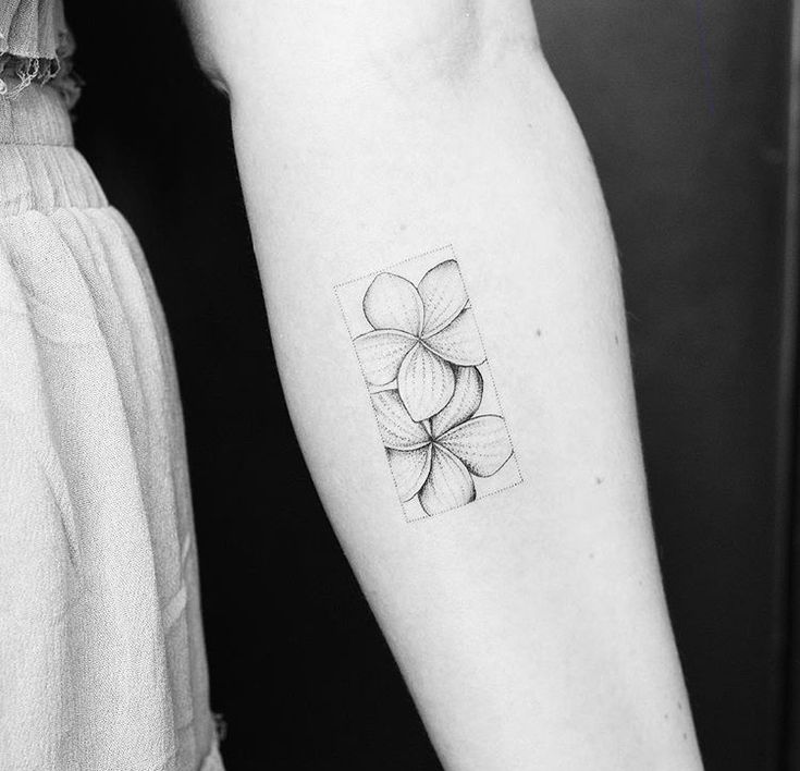 a woman's arm with a tattoo on it that has four flowers in the center