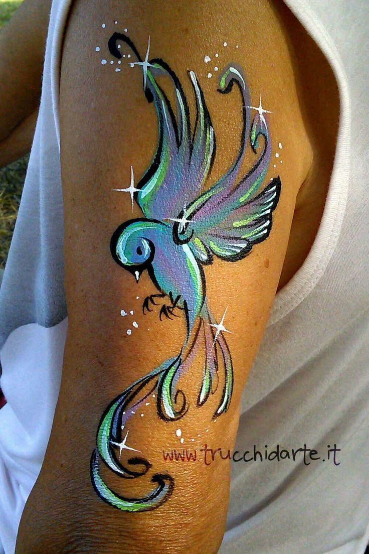 a colorful bird painted on the arm of a woman's left arm and shoulder