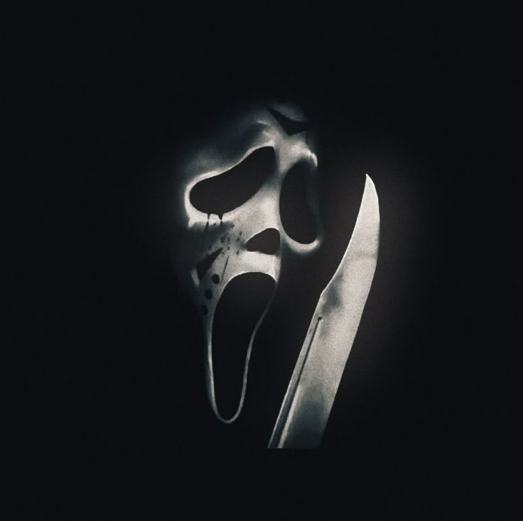 a black and white photo of a scary mask