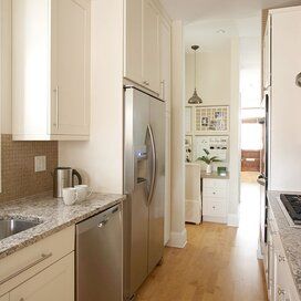 a kitchen with white cabinets and stainless steel appliances