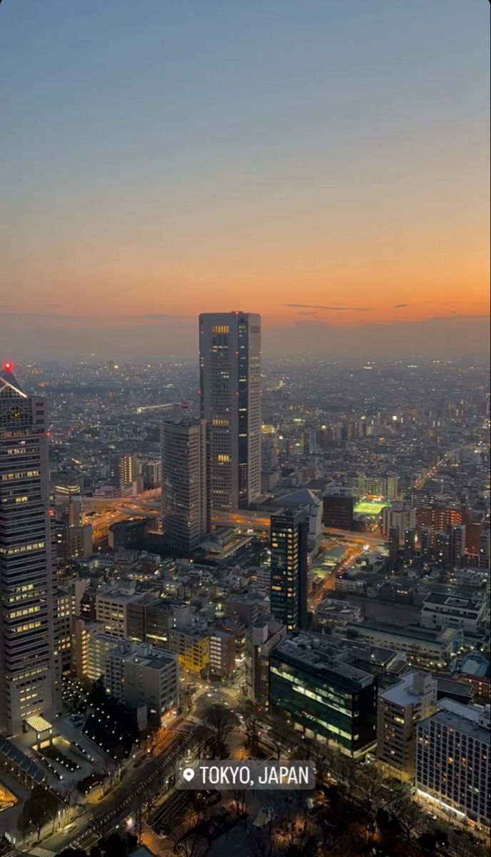 an aerial view of the city at night with skyscrapers and other buildings in the foreground