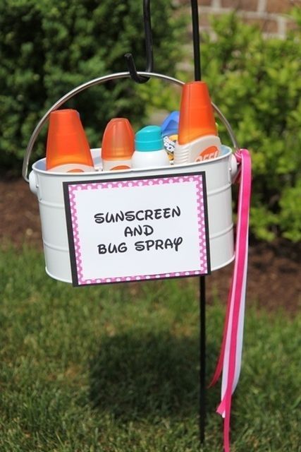 a bucket filled with baby bottles sitting on top of a grass covered field