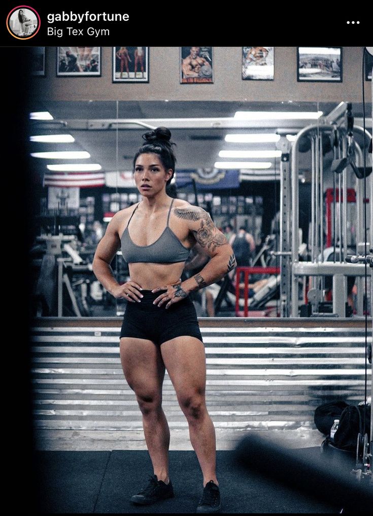 a woman standing in the middle of a gym