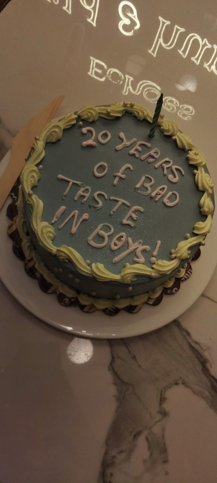 a cake that is sitting on top of a table with a sign in the background