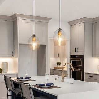 a large kitchen with an island and two pendant lights