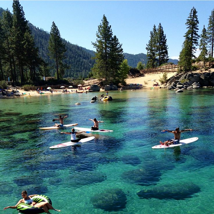 several people are paddling on their surfboards in the clear water